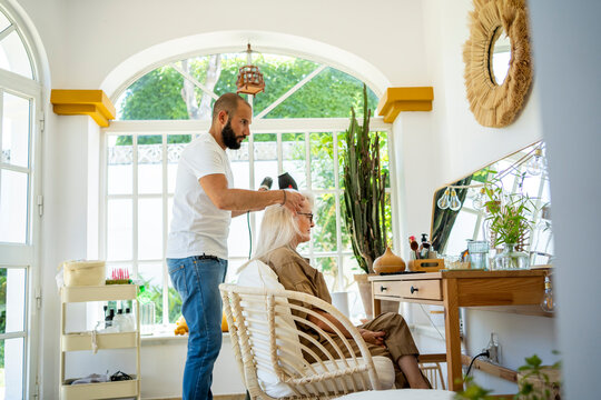 Hairdresser combing to woman's hair