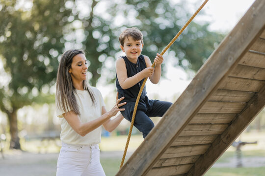 Mother helping her son climb