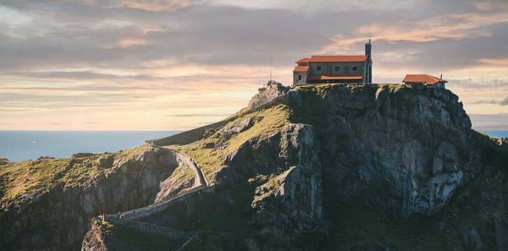 Rocky island San Juan de Gaztelugatxe against sunset sky aerial view