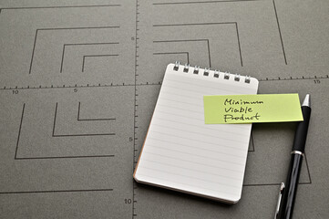There is sticky note with the word of Minimum Viable Product on gray board.