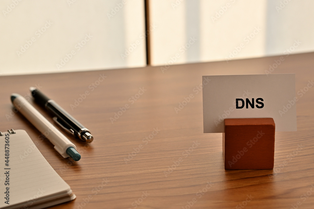 Aufkleber there is a card on paper stand with the word of dns which is an abbreviation for on the desk with a 