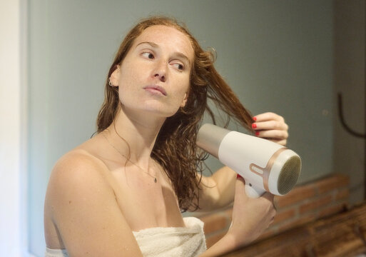 Ginger Woman Blow Drying Hair