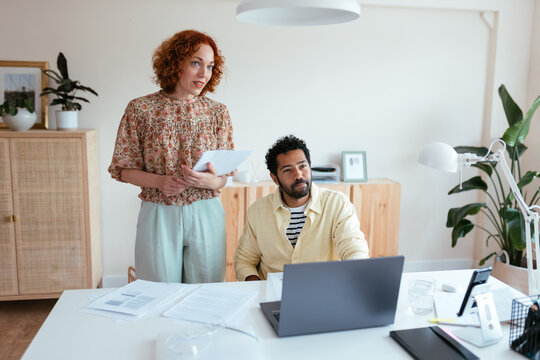 Multiracial colleagues looking away during work on project