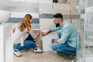 Middle age couple choosing ceramic tiles for their new bathroom