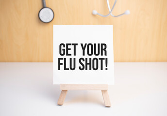 Get Your Flu Shot sign on small wood board rest on the easel with medical stethoscope
