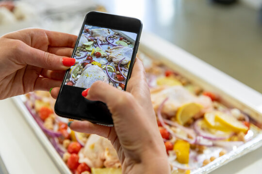 Woman Uses Phone to Take a Picture of Chicken