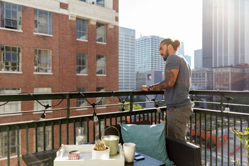 Man Enjoys City View Off Balcony