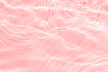 Surface of light toned in pink transparent swimming pool water texture with circles on the water. Trendy abstract nature background. Water waves in sunlight banner with copy space.