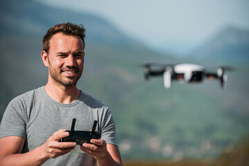 Positive male traveler controlling UAV copter