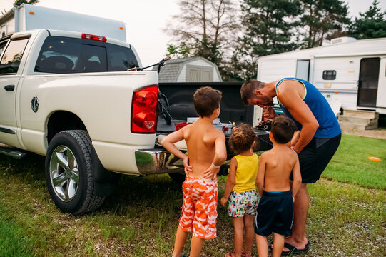 Father teaching kids how to prepare fishing line. 