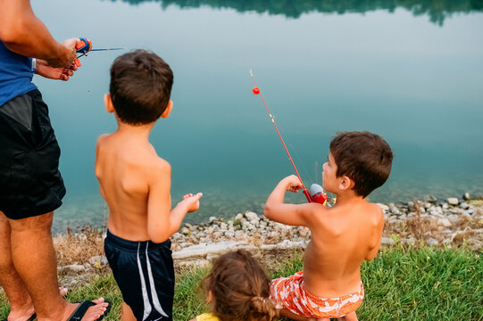 Family fishing together at pond. 