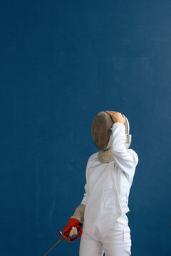 Anonymous fencer touching protective mask