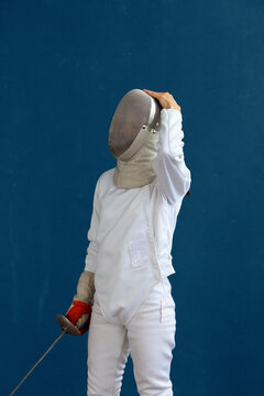 Unrecognizable fencer adjusting helmet during training
