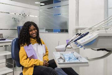 Black girl in dental chair smiling at camera