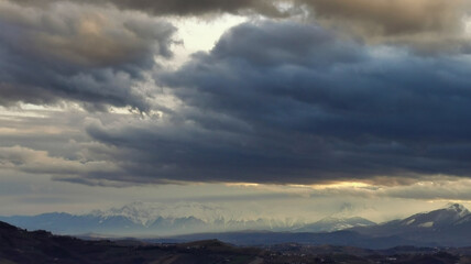 Enormi nuvole grigio azzurre sopra le montagne e le valli dell’Appennino