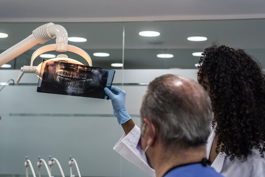 Dentists examining patient teeth x-ray