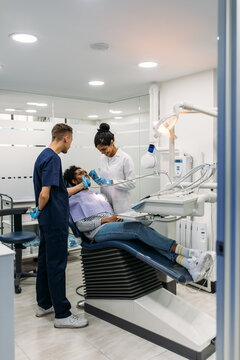 Dentists curing teeth of patient in clinic