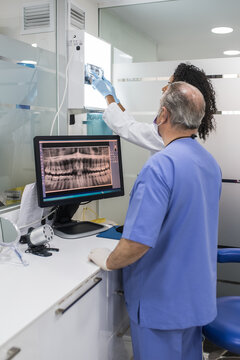 Dentists examining patient teeth x-ray
