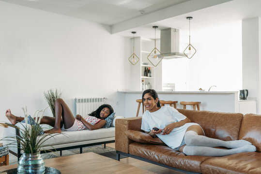 Mother and daughter lying down watching tv