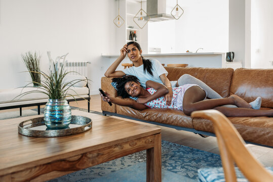 Mother And Daughter Lying Down Watching Tv