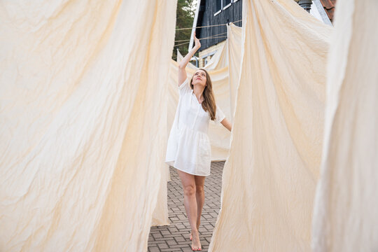 Female Dancer In Background Of Hanged Bed Linen
