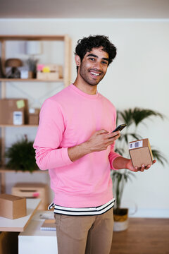 Positive Hispanic man scanning bar code on parcel