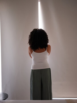 Woman opening blinds on window