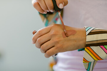 Anonymous woman testing liquid lipstick on hand