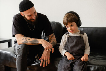 A Berliner Guy And A Little Kid Are Listening To Some Music 
