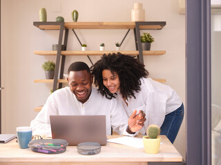 Smiling Black couple in office.