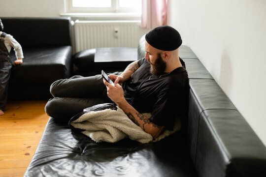 Tattooed Smiling Berliner Guy Laid On The Couch 