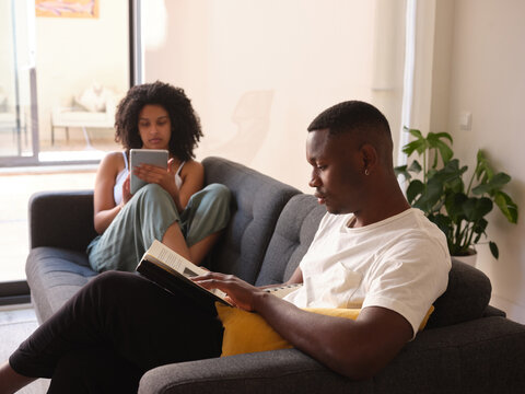 Black couple reading home.
