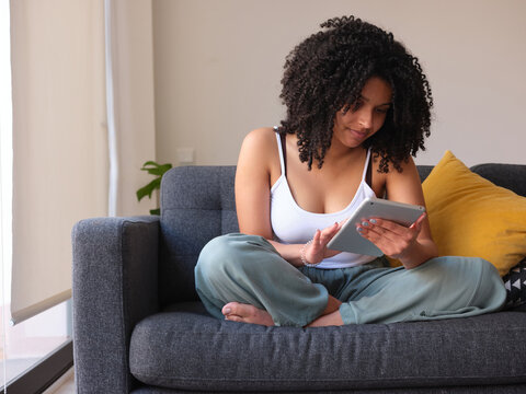Woman using tablet on couch.