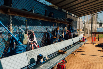 Baseball equipment scattered along bench.