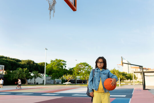 Kid with basketball ready to play on the court