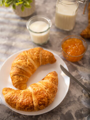 European breakfast. Croissants, jam and milk. The butter knife is on the plate. Restaurant and hotel business. Advertising business. Cafe, diner, home cooking. Book of recipes. View from above.