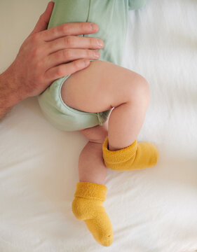 Baby's feet with daddy's hand in the frame 