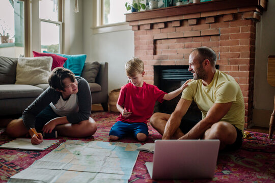 Dad laughs with sons while planning trip