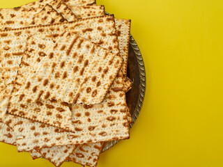 The celebration of the Jewish Passover is a great religious holiday. Traditional Jewish matzah on a yellow background. View from above. High angle view. Restaurant, home cooking.
