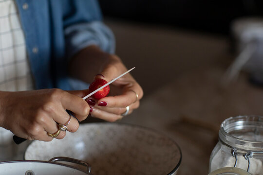 Anonymous Woman Cutting Strawberry For A Cake