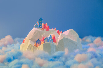Miniature snowy village on cloud