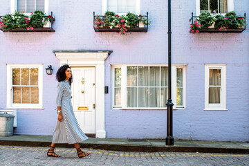 Woman walking by beautiful multicolored houses facades
