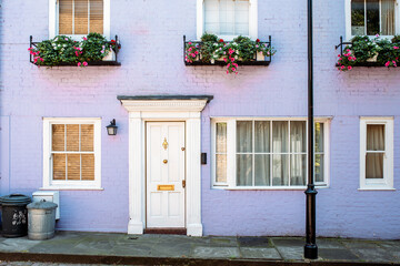 Beautiful lilac house facade with flowers on the windows