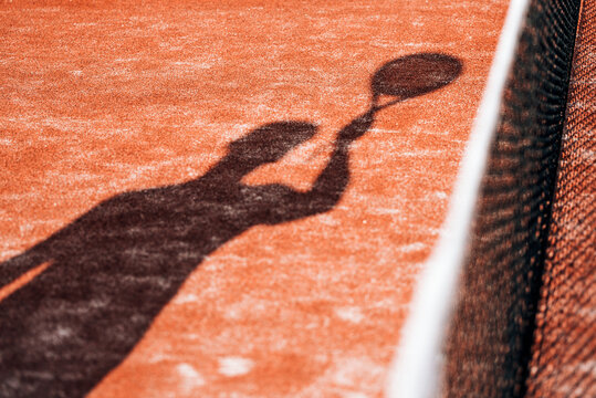 shadow on court floor of man playing padel