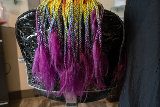 Rainbox box braids draped over salon chair