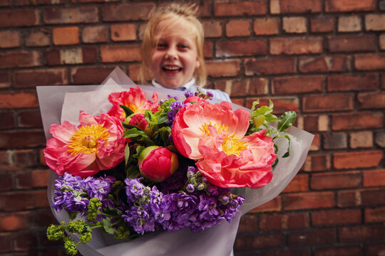 Child Holding A Large Bunch Of Peony Flowers