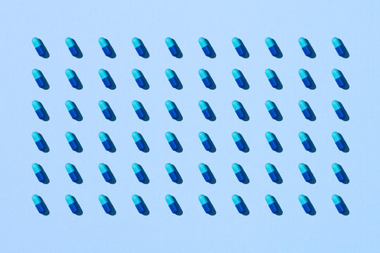 Capsule pills pattern on a blue background