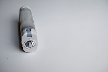 LED emergency light is white with two sides that can produce light, can be recharged using USB, photographed closely up
