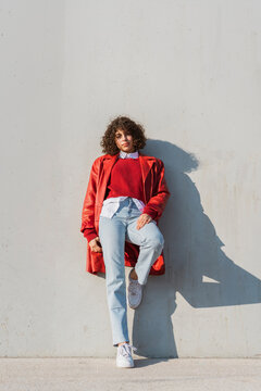 Portrait of cool woman leaning against wall