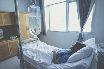 Patient receiving fluids through an intravenous line in the wrist while admitted in hospital. IV therapy is a medical technique that delivers fluids and nutrition directly into a person's vein.